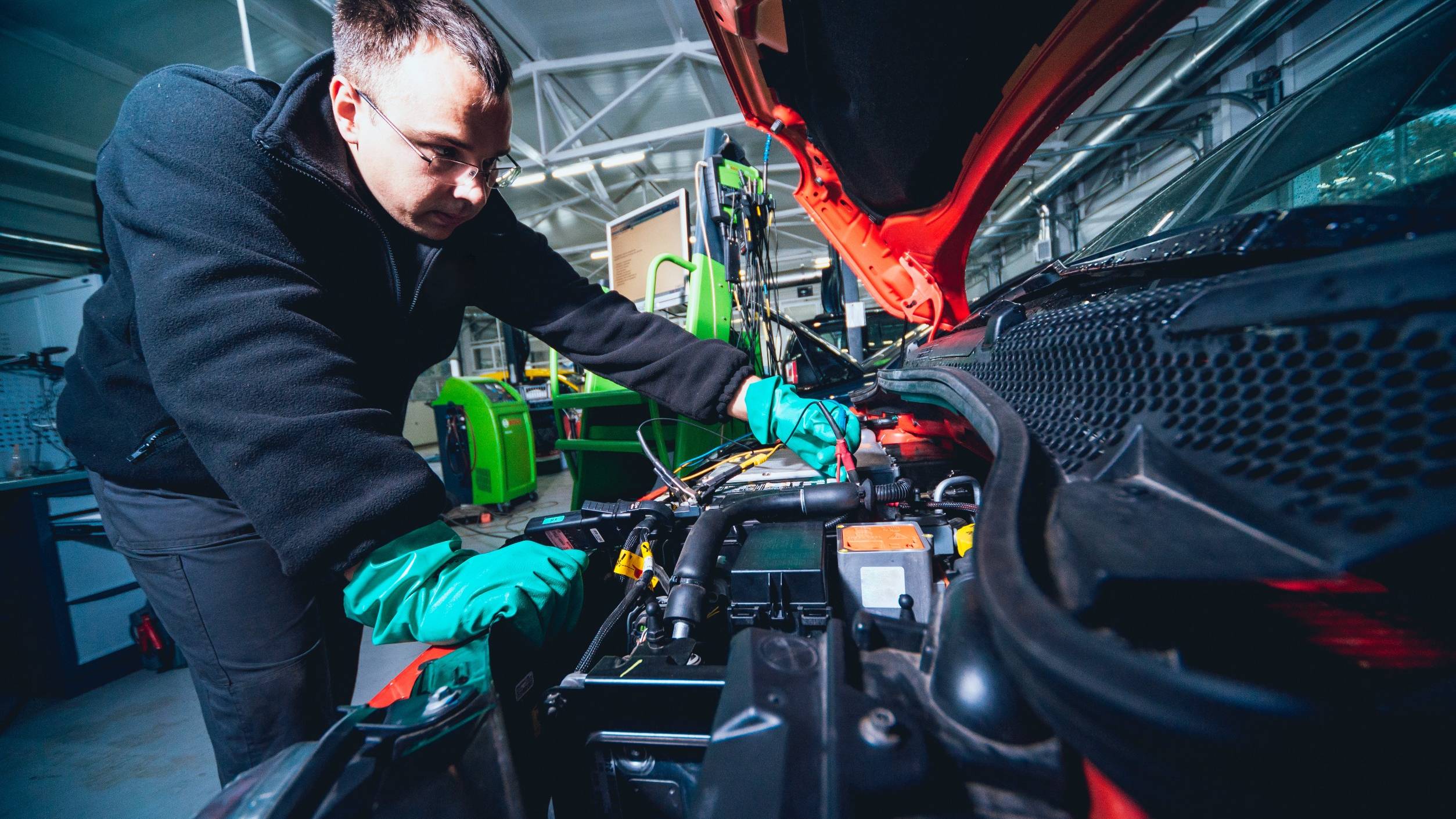Garages struggle with training time needed for EV skills - picture shows a mechanic working on an EV engine