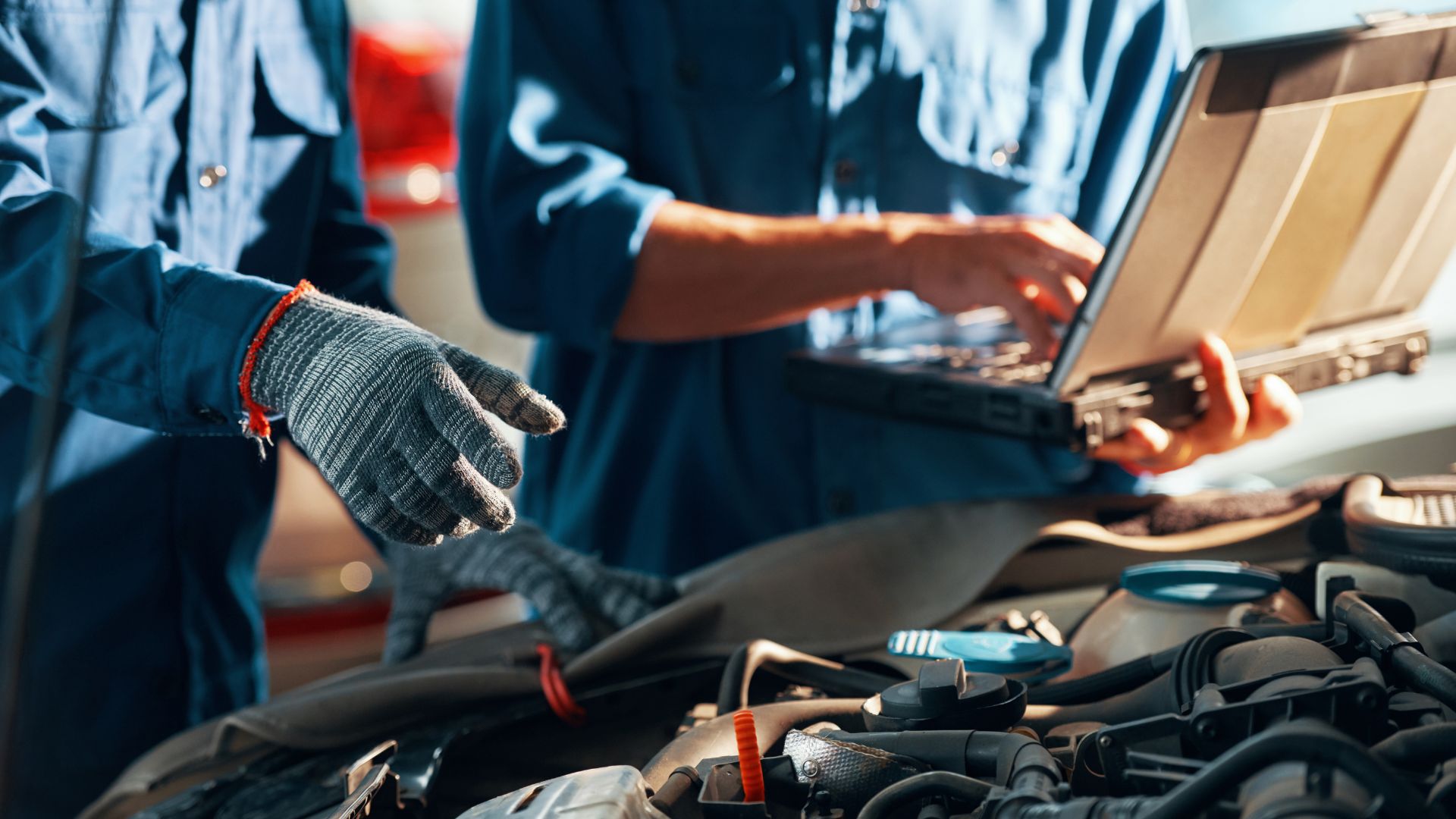Automotive Future Survey - Image of two vehicle technicians overlooking a car engine, one is holding a laptop